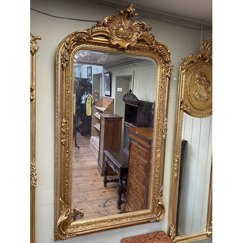 386 - Gilt framed rectangular bevelled wall mirror with foliate crest, 157cm by 85cm.