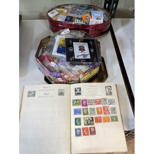 64 - Two tins of pin badges and stamp album.