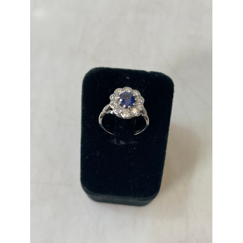 191 - Stunning sapphire and diamond cluster 18 carat white gold ring, the cushion sapphire bordered with t... 