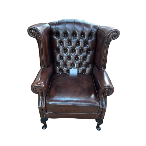 375 - Thomas Lloyd brown buttoned leather and studded wing armchair.