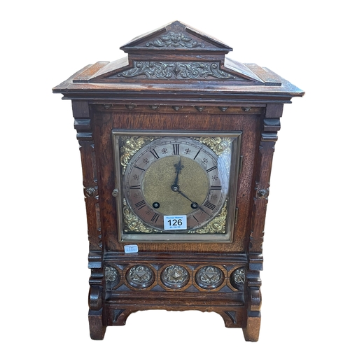 126 - A Continental oak and gilt framed bracket clock with lion head side decoration, 45cm high.