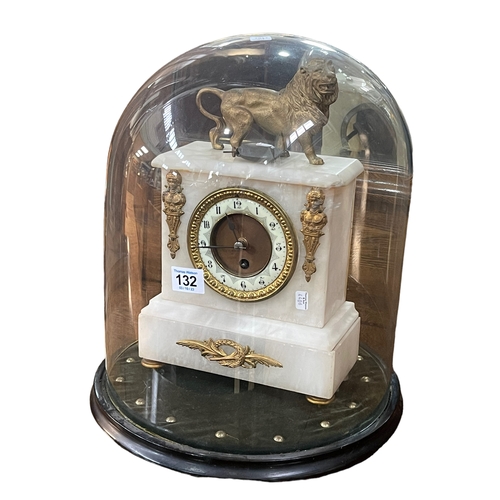 132 - Victorian ornate gilt and onyx mantel clock with a lion crest under a glass dome, 40cm high.