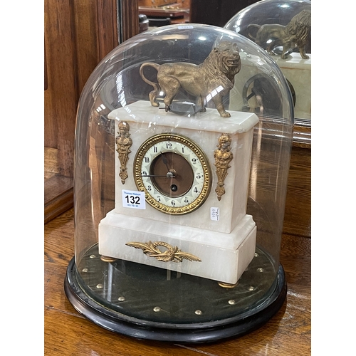 132 - Victorian ornate gilt and onyx mantel clock with a lion crest under a glass dome, 40cm high.