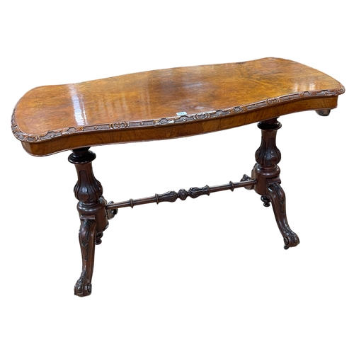 341 - Victorian walnut centre table of serpentine form raised on two carved pedestals joined by turned str... 