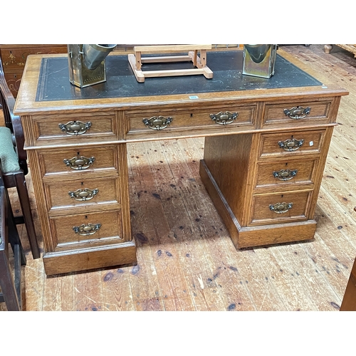 352 - Late 19th/early 20th Century oak nine drawer pedestal desk, 74cm by 122cm by 68cm.