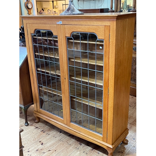 353 - Early 20th Century golden oak leaded glazed two door bookcase, 139cm by 121.5cm by 39cm.