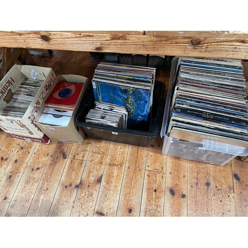 48 - Four boxes of LP and single records including Bruce Springsteen, Queen, etc.