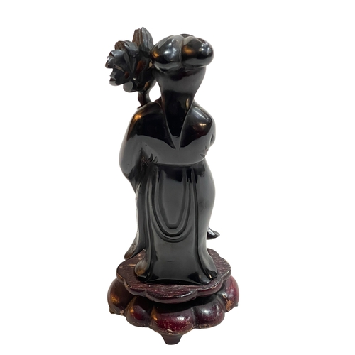 174 - Chinese carved cherry amber figure on wood base, 20cm high.