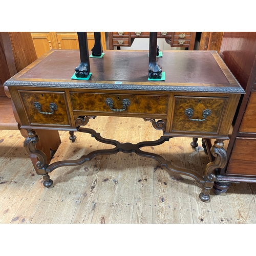 399 - Walnut three drawer writing desk on ornate shaped legs joined by shaped cross stretcher, 76cm by 107... 