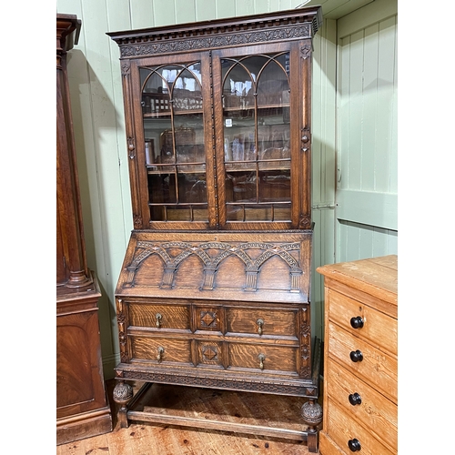 402 - 1920's Lees style carved oak bureau bookcase having two glazed panel doors above a fall front enclos... 