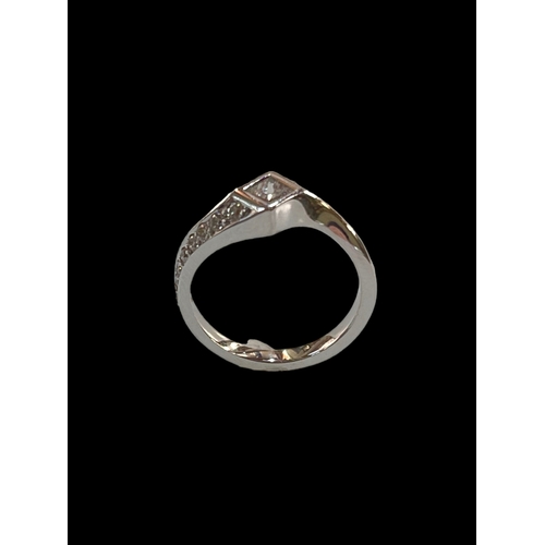 179 - Twist design diamond ring, the central diamond individually set with smaller diamonds running around... 