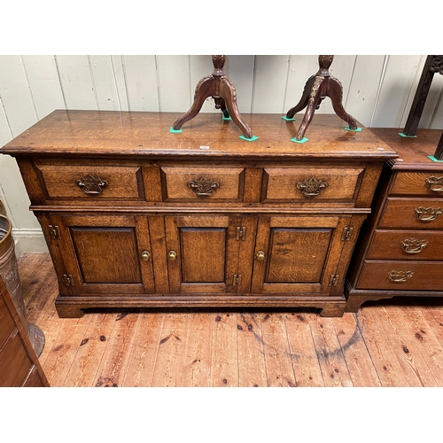 392 - Period style oak dresser having three drawers above three fielded panel doors, 85cm by 137cm by 48cm... 