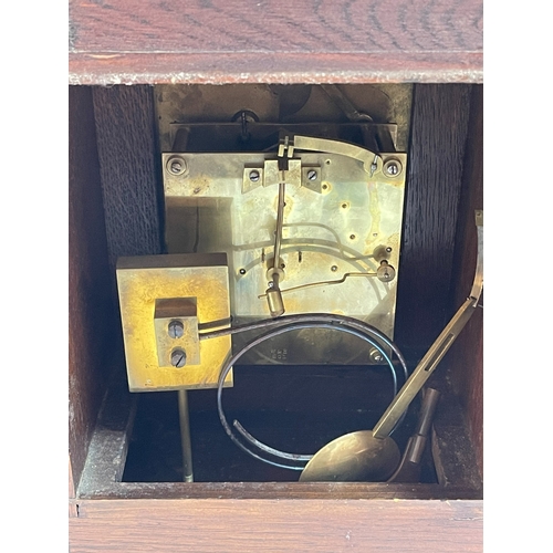 144 - Oak and brass mounted mantel clock with brass and silvered dial, 42cm.