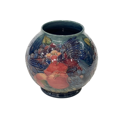 265 - Moorcroft Pottery Finches and Fruit vase of globe form, tubelined with birds pecking fruit, 17cm.