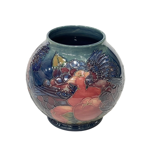 265 - Moorcroft Pottery Finches and Fruit vase of globe form, tubelined with birds pecking fruit, 17cm.