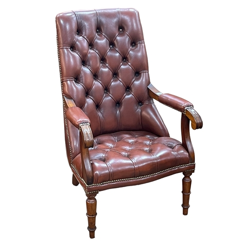 336 - Brown buttoned leather and brass studded open armchair.