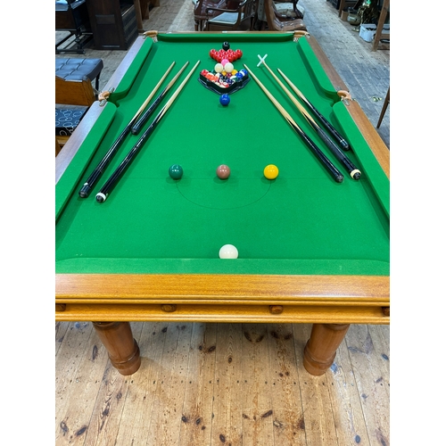 357 - Slate bed snooker table on turned leg base, 77cm by 121cm by 227cm, together with cues, snooker and ... 