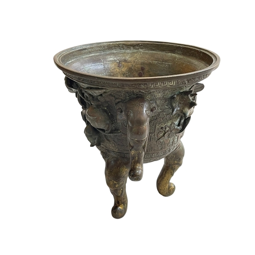 162 - Antique Chinese/Eastern bronze three footed vase decorated with elephant and floral design, 24cm.