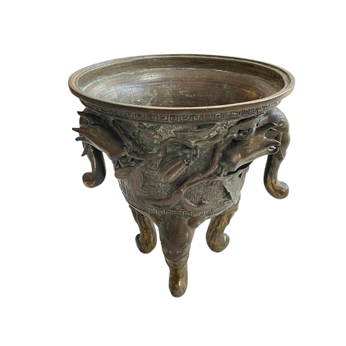162 - Antique Chinese/Eastern bronze three footed vase decorated with elephant and floral design, 24cm.