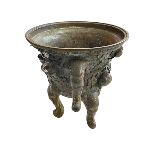 162 - Antique Chinese/Eastern bronze three footed vase decorated with elephant and floral design, 24cm.