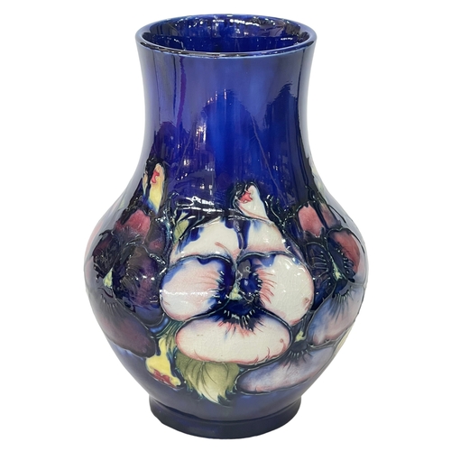 182 - Walter Moorcroft baluster vase decorated with pansy design on blue ground, 22cm.