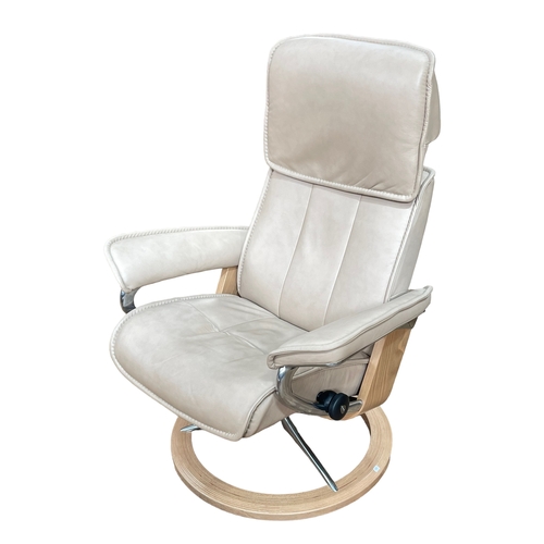 270 - Stressless Ekornes fawn leather reclining swivel chair and footstool.