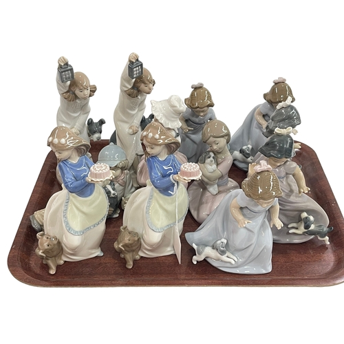 12 - Twelve Nao figures, all with or holding dogs.