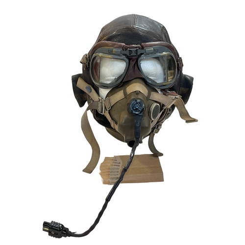 135 - A WWII period brown leather flying helmet, goggles and face mask, the helmet retaining original head... 