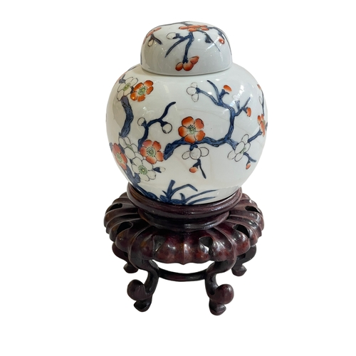 168 - Chinese ginger jar on wood stand decorated with floral design, iron red mark to base.