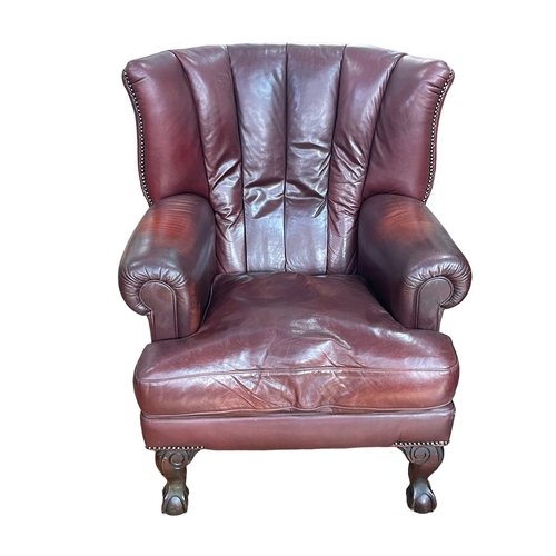 320 - Tetrad burgundy leather and studded armchair on ball and claw legs.