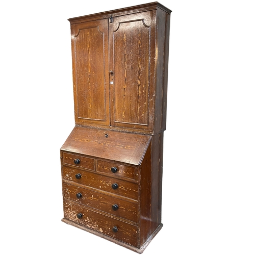 366 - 19th Century scumbled pine bureau bookcase having two panelled doors above a fall front with five dr... 