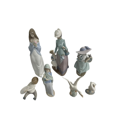 12 - Three Lladro figures and two geese and two Nao figures.