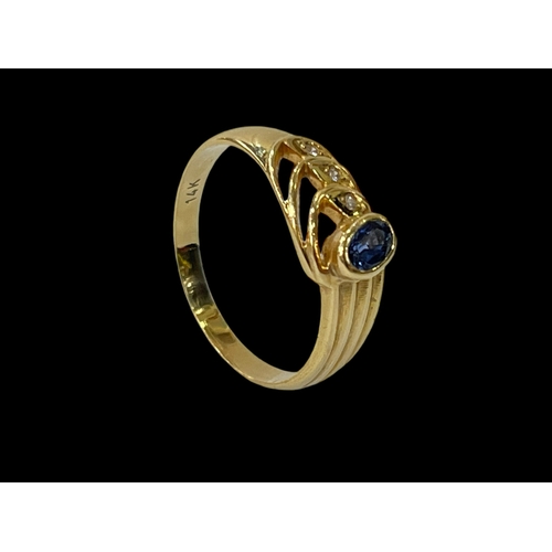 246 - 14 carat yellow gold Ceylon sapphire and three stone diamond ring, size Q.