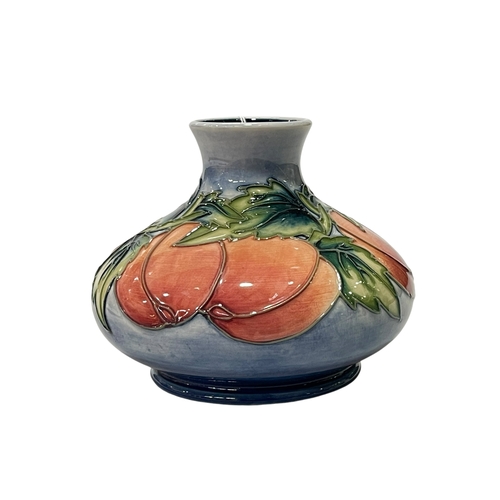 323 - Moorcroft Pottery Squat vase decorated with peach design on light blue ground, dated 96, 10.5cm.