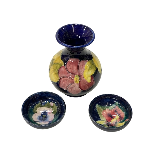 342 - Two Moorcroft Pottery pin dishes decorated with orchid and pansy on blue ground, each 8cm in diamete... 