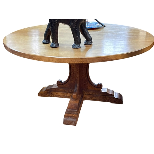 426 - The Country Craftsman, Nottinghamshire, circular oak dining table on cruciform base, 77cm by 145cm d... 