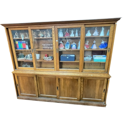 433 - Early 20th Century oak office cabinet bookcase having four sliding glazed panel doors above four sli... 