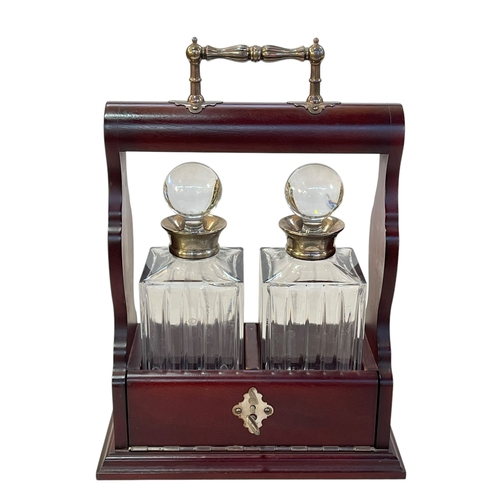 146 - Mahogany tantalus and two silver collared decanters.