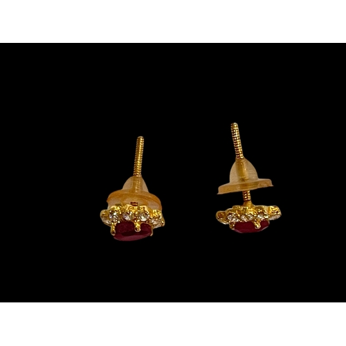 212 - Pair ruby and diamond cluster earrings in yellow gold, each oval ruby with ten diamond border.