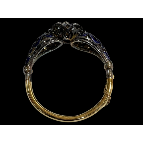 215 - Impressive 18 carat gold, diamond and blue enamel bangle, having elevated 0.25 carat diamond at the ... 