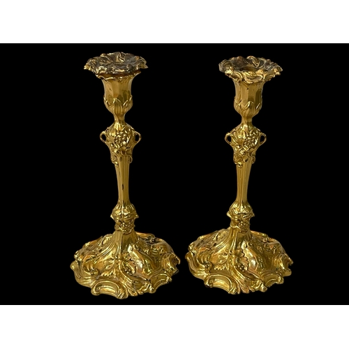 254 - Pair of ornate gilt candlesticks with loose nozzles, 27cm.