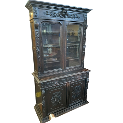 382 - Victorian carved oak cabinet bookcase having two glazed panel doors above two drawers with two carve... 