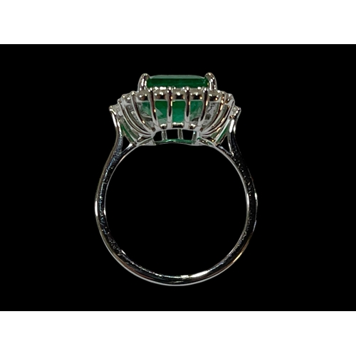 128 - Emerald and diamond cluster ring set in 18 carat white gold, rectangular emerald 12mm by 9mm, 4.65 c... 