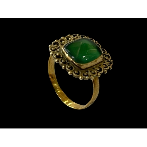 148 - Green jade and gold ring with filigree border, size P.