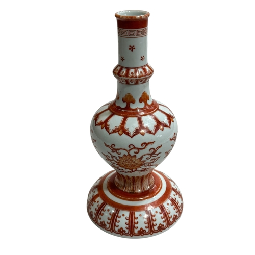 143 - Chinese iron red holy water vase, the baluster body on a domed base decorated with lotus sprays, 23c... 