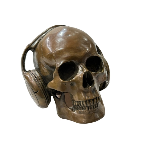 216 - Novelty brass model of a skull wearing headphones.