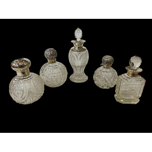 242 - Collection of five silver topped and mounted scent bottles.