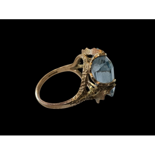 145 - Emerald cut aquamarine colour gem, ornate set 9 carat gold ring, size N.