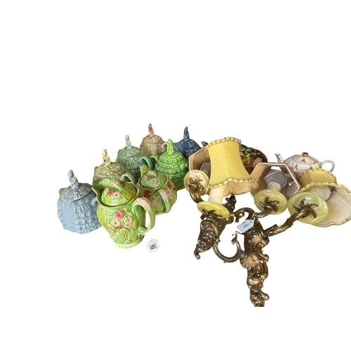 92 - Six Sadler Ye Daintee Ladyee teapots, Melba ware teapot and jug, pair of gilt and onyx wall lights.