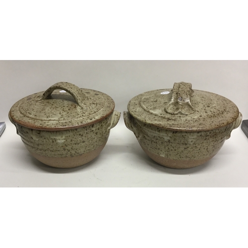 493 - A pair of lidded stoneware pottery soup bowls with lug handles of fluted speckled design. Apparently... 